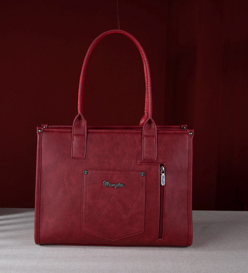 A red faux-leather tote bag with dual top handles, a front pocket with a silver-tone 'Mangalya' logo, and a vertical zippered pocket on the right side, set against a dark red background.