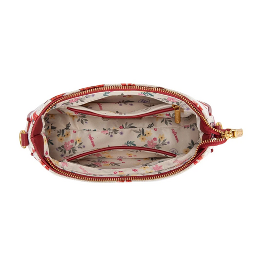 An open top view of a small shoulder bag with a cream floral print exterior, red trim, and a matching floral interior lining with gold-tone zippers.