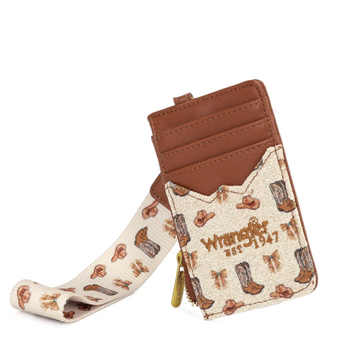 A small brown faux-leather card holder wallet with a western print wrist strap. The front pocket features a cream-colored cowhide-patterned flap with brown boots and logos, including 'Wrangler Est.