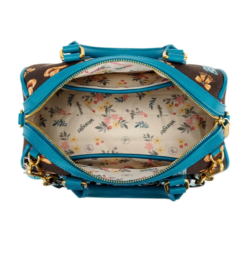 An open designer handbag with a brown coated canvas exterior featuring a floral print, turquoise blue leather trim, and a beige floral lining with 'Vogue' branding.