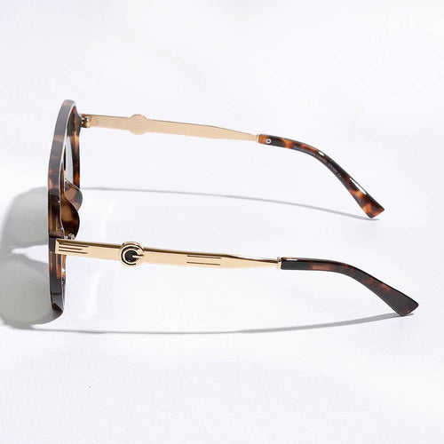Sunglasses with gold frame and tortoiseshell arms on a white background