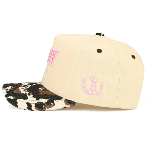 Beige cap with pink logo and leopard print brim on a white background