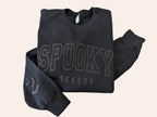 black crewneck with spooky season wrote on it on white background