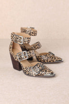 Pair of leopard print high-heeled shoes with buckle details on a beige background