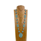 Turquoise necklace on a wooden mannequin against a white background