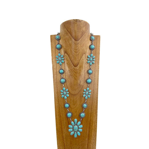 Turquoise necklace on a wooden mannequin against a white background