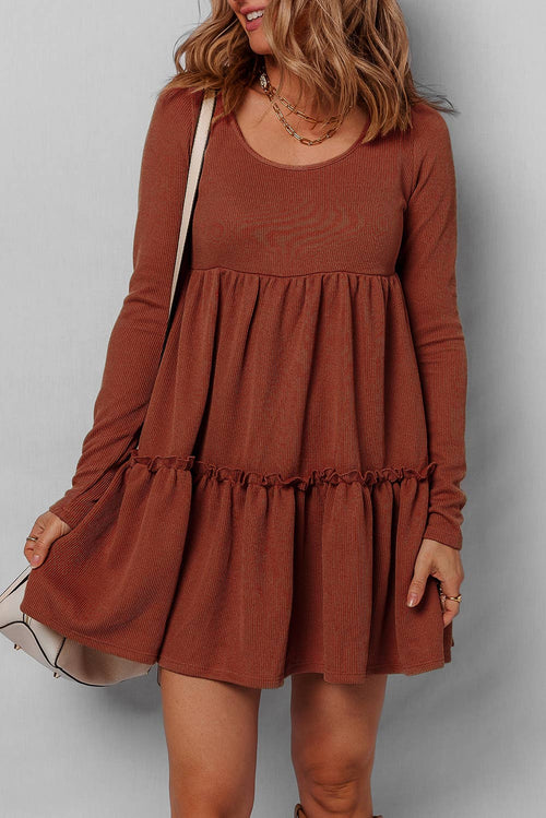 Woman wearing a brown dress against a plain background
