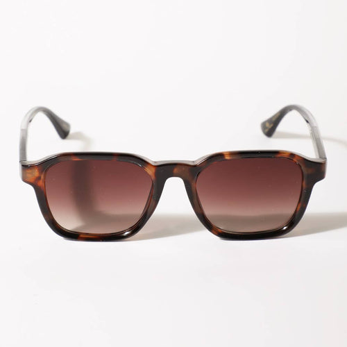 Sunglasses with tortoiseshell frame and brown gradient lenses on a white background