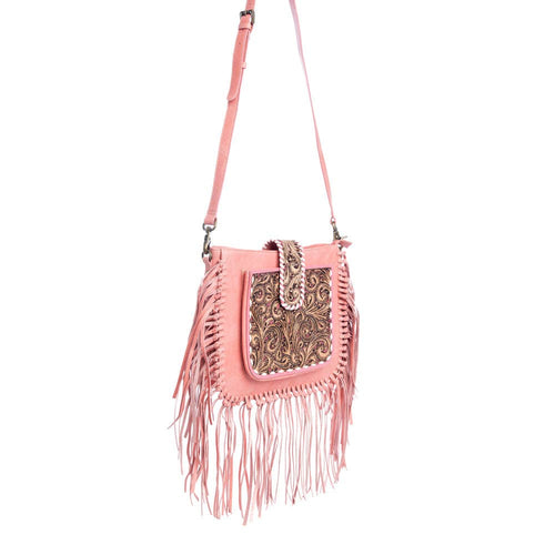 Pink handbag with fringe and intricate design on a white background