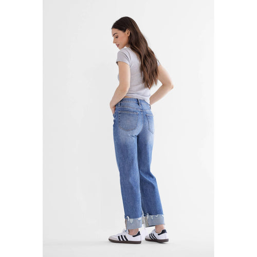 Woman wearing blue jeans and a white t-shirt on a white background