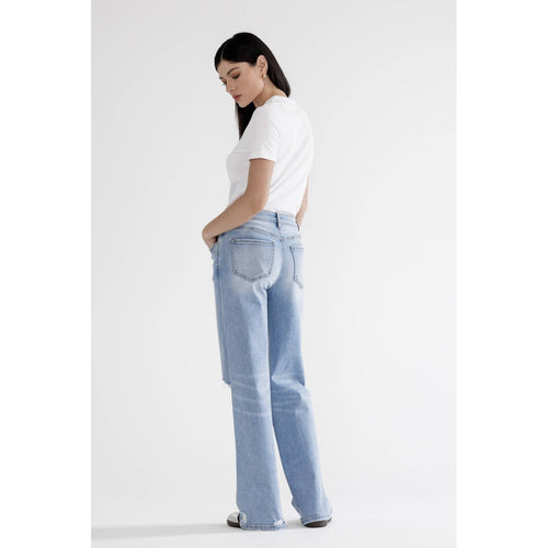 Woman wearing light blue jeans and a white t-shirt on a white background