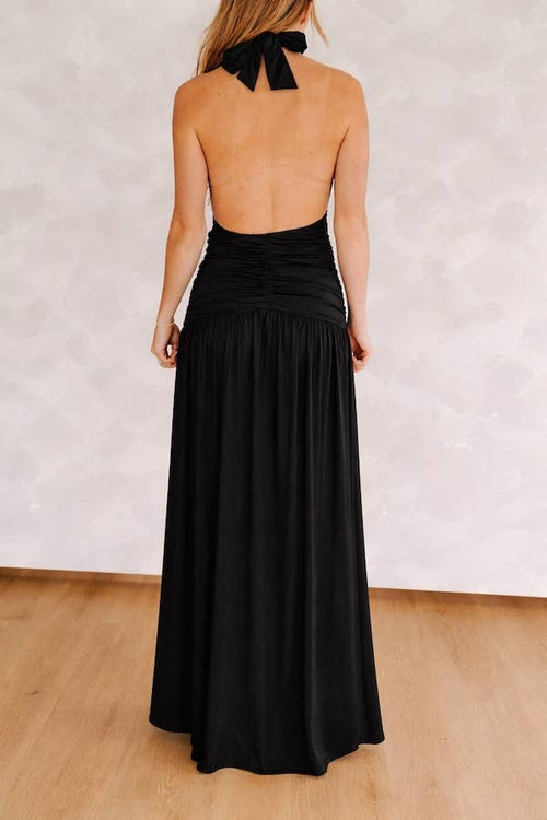 Black halter neck dress with open back on a plain background