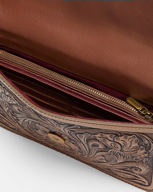 Close-up of a brown leather wallet with intricate embossed design on a white background