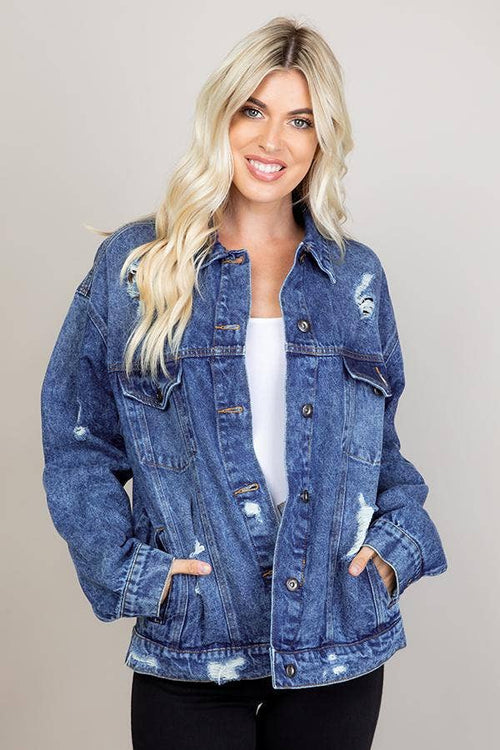 Woman wearing a blue denim jacket with a plain background