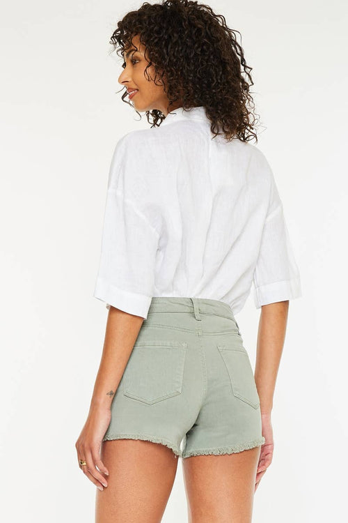 Woman wearing a white shirt and light green shorts on a white background