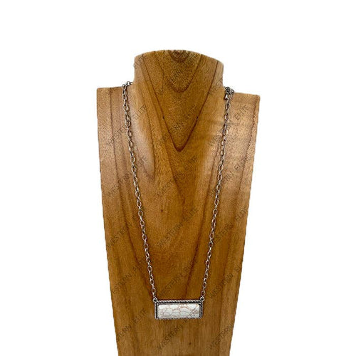 Necklace with a rectangular pendant on a wooden stand against a white background