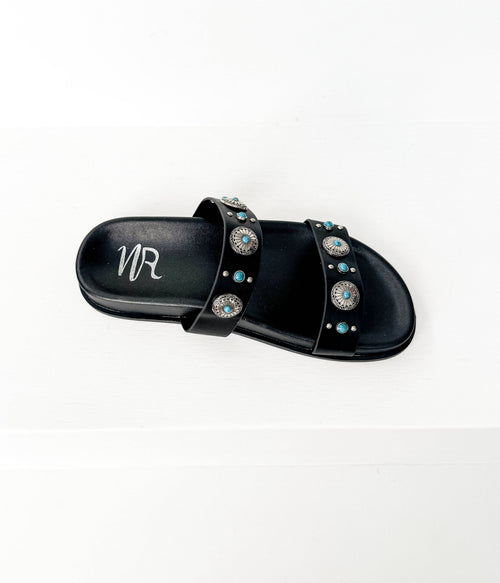 Black sandals with decorative studs on a white background