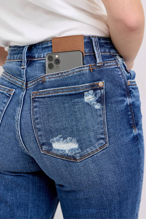 Blue jeans with a phone case on a white background