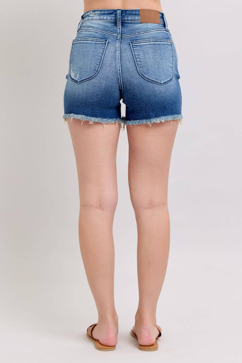 Person wearing blue denim shorts on a plain background