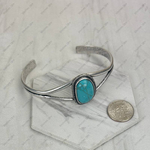 Silver bracelet with turquoise stone on a white background