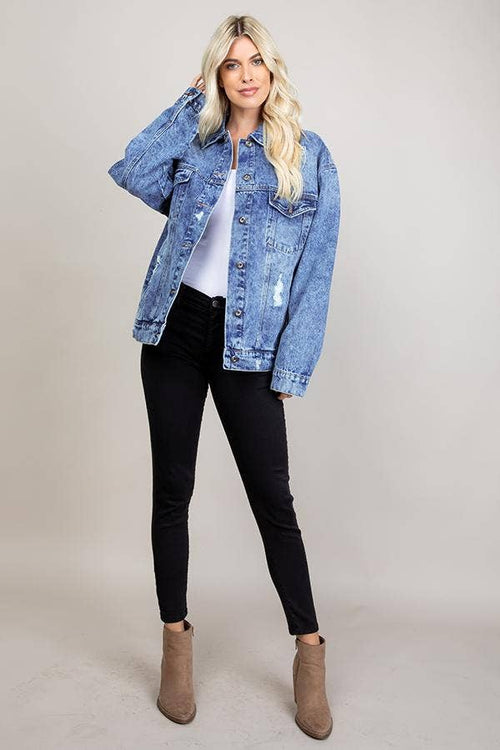 Woman wearing a blue denim jacket on a plain background