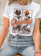 Person wearing a white t-shirt with a cowboy graphic and text, sitting outdoors.