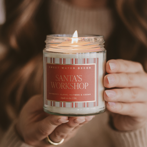 Candle labeled 'Santa's Workshop' held by a person