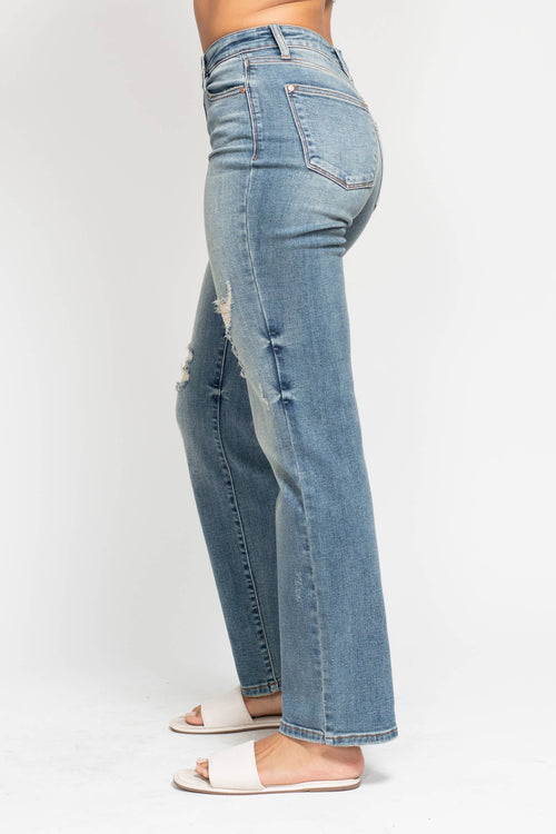 Light blue jeans with slight distressing on a white background