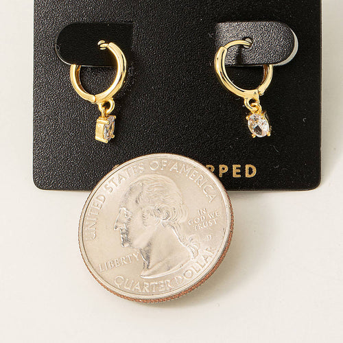 Gold hoop earrings with small diamonds on a black card, shown with a quarter for scale.