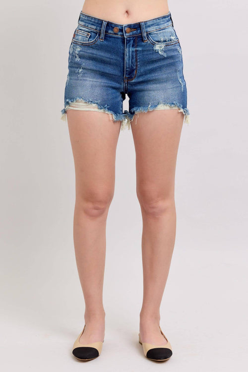 Person wearing blue denim shorts on a plain background