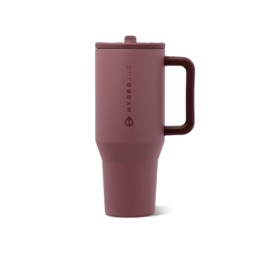 A matte dusty rose travel tumbler with a matching lid and integrated handle, featuring the HydroJug logo printed vertically on the front, set against a plain white background.