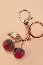 Keychain with cherry design on a beige background