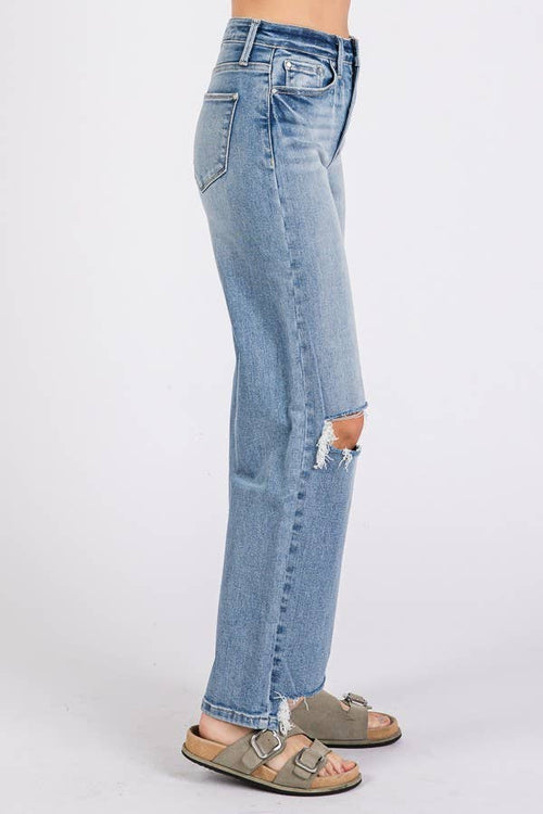 Light blue jeans with a slight distressed look worn by a person on a white background