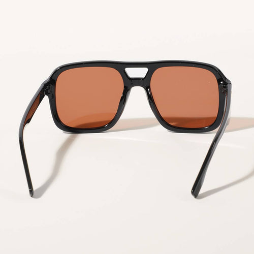 Sunglasses with brown lenses and black frame on a light beige background