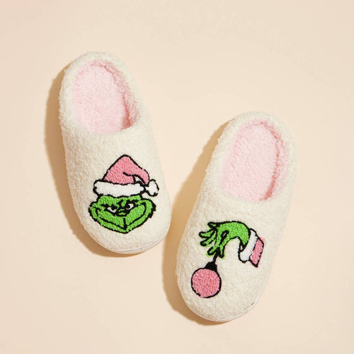 Pair of slippers with Grinch design on a beige background