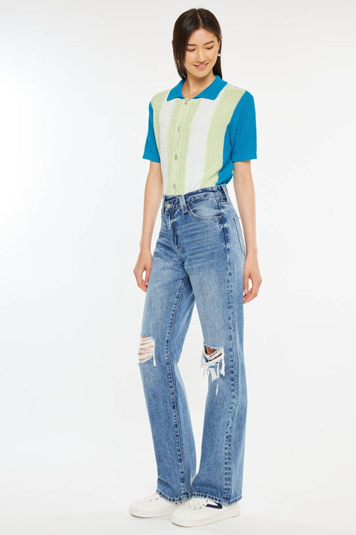 Person wearing a colorful striped shirt and blue jeans on a white background