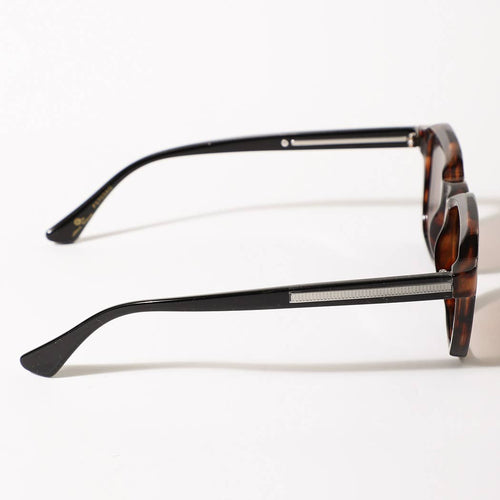 Sunglasses with tortoiseshell frame and black arms on a white background