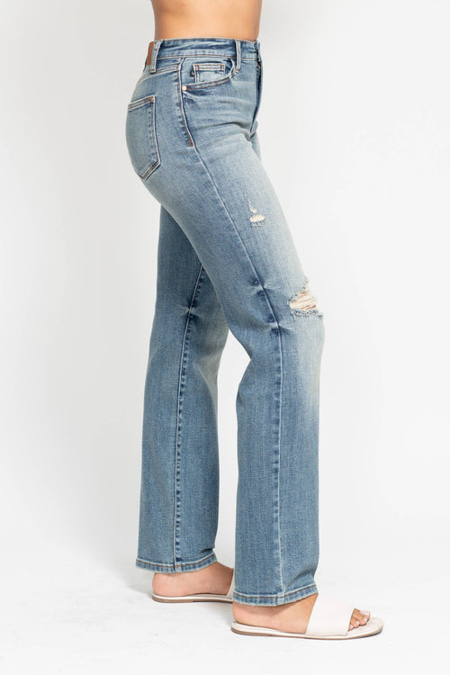 Light blue jeans with slight distressing on a white background