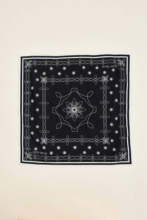 Black bandana with white patterns on a beige background