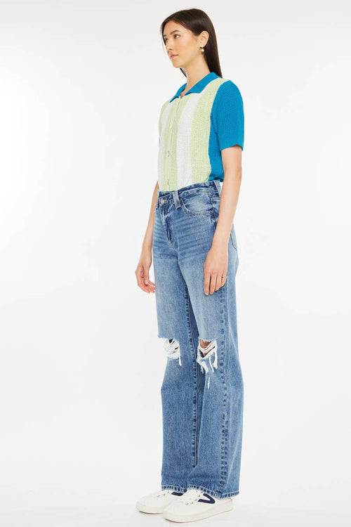 Person wearing a colorful shirt and blue jeans on a white background