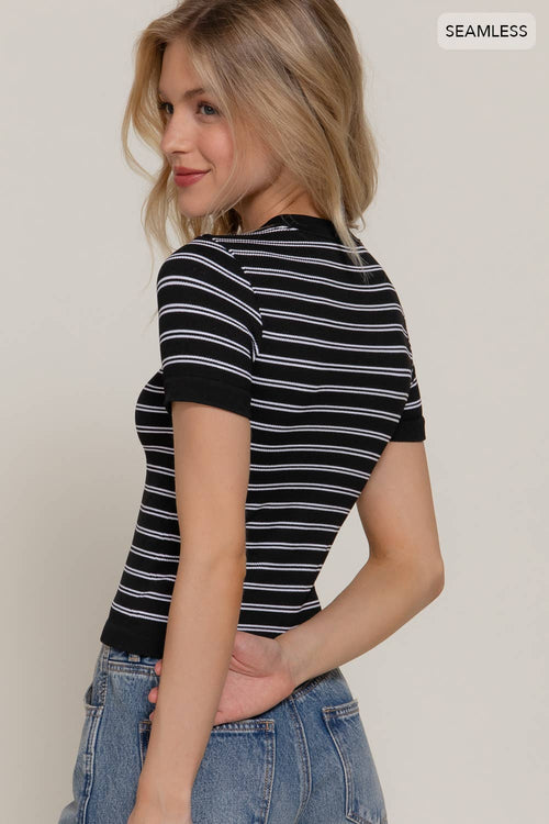 Woman wearing a black and white striped shirt with a plain background