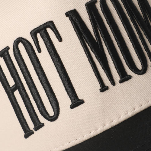 Close-up of 'HOT Mom' text embroidered on a beige background