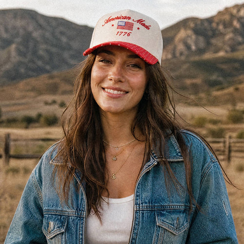 Woman wearing an 'American Made' cap with mountains in the background