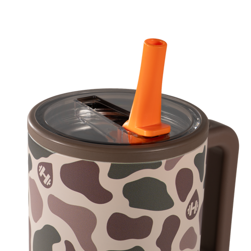 Tumbler with a giraffe pattern and orange straw on a white background