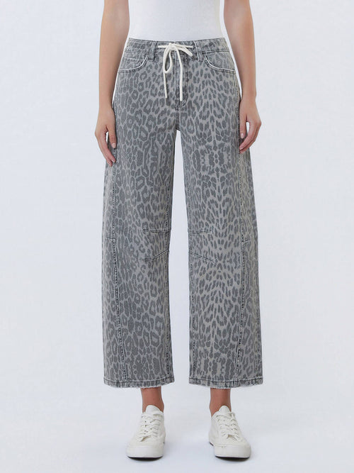Gray leopard-print wide-leg cropped jeans with a white drawstring waist, modeled with white sneakers against a light gray studio background.