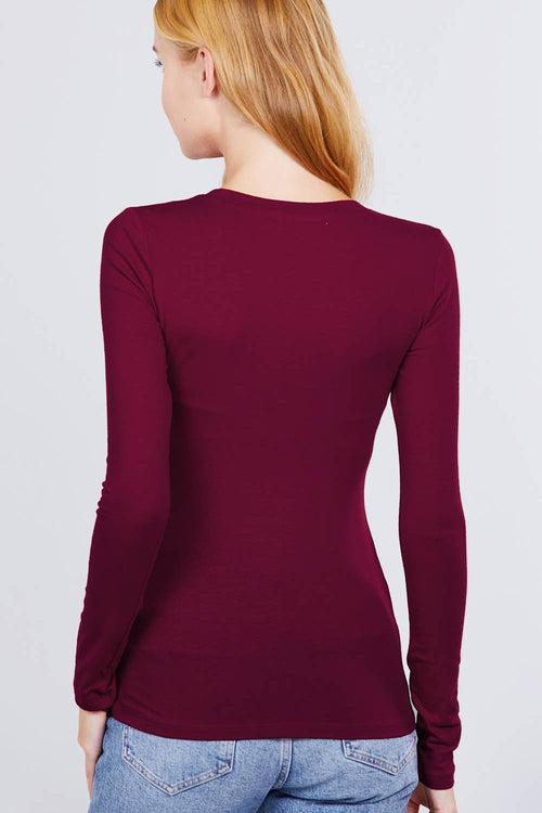 Person wearing a burgundy long-sleeve top against a plain background