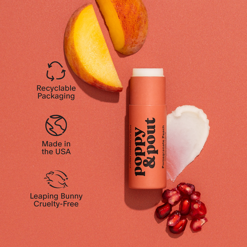 Poppy & Pout lip balm with pomegranate pieces and a peach slice on a pink background