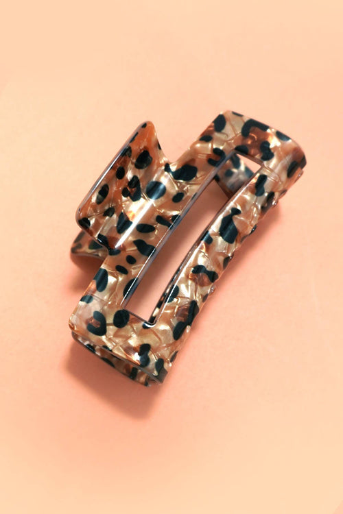 Leopard print hair clip on a peach background