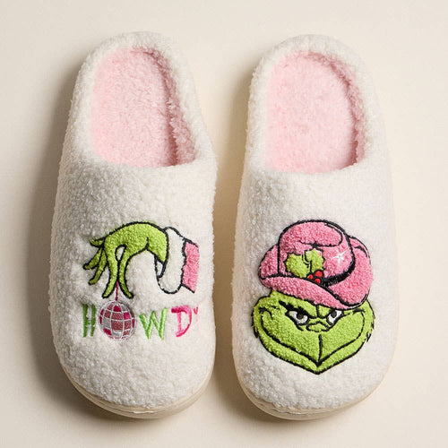 Pair of slippers with Grinch-themed designs on a beige background