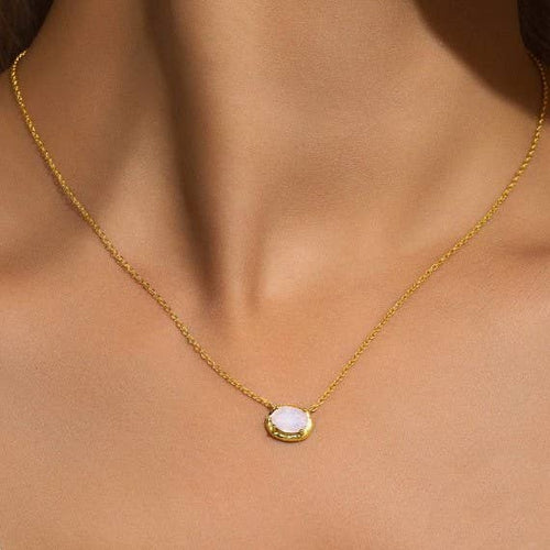 Gold necklace with a pendant on a person's neck